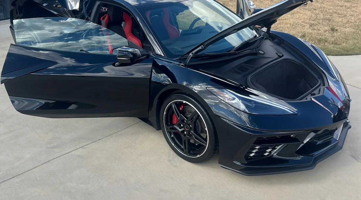 Black Chevrolet Corvette with doors up after a paint-and-shine detail