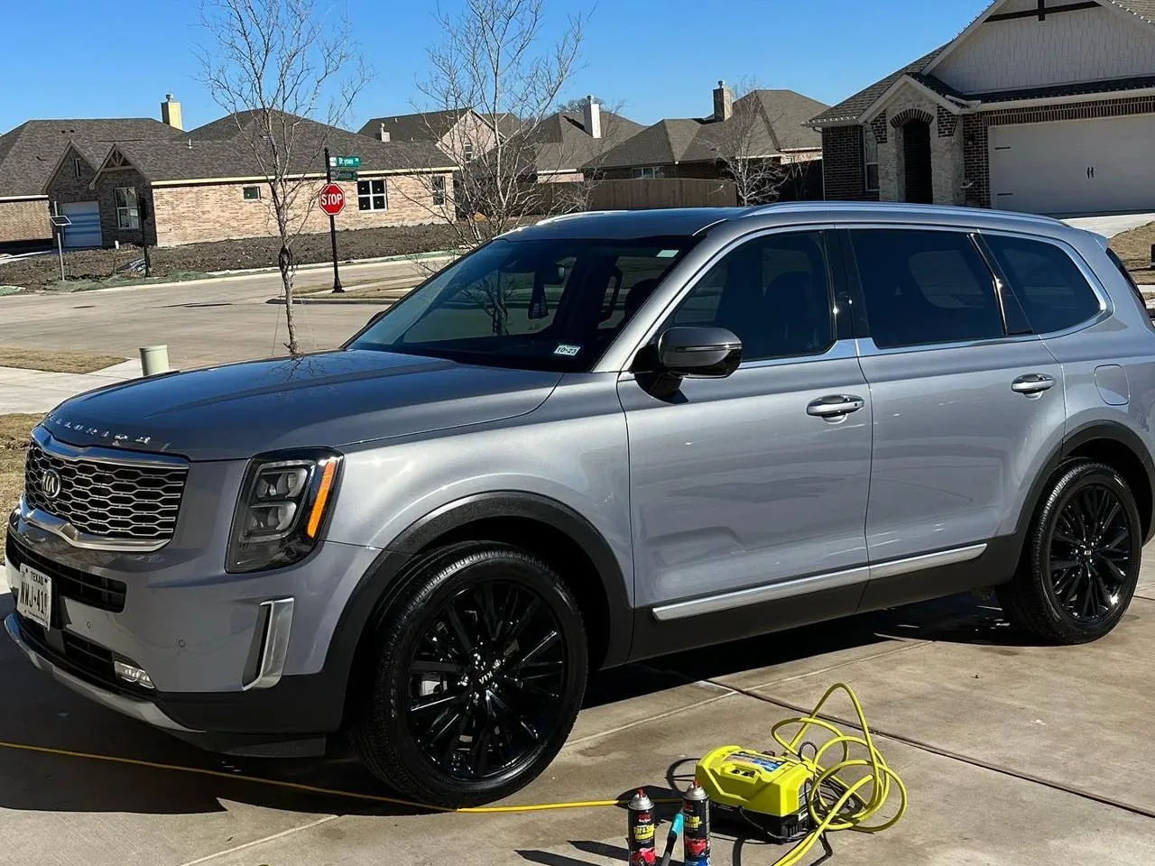 Infiniti QX80 beside Shelby's mobile wash buckets, hoses, and detailing equipment