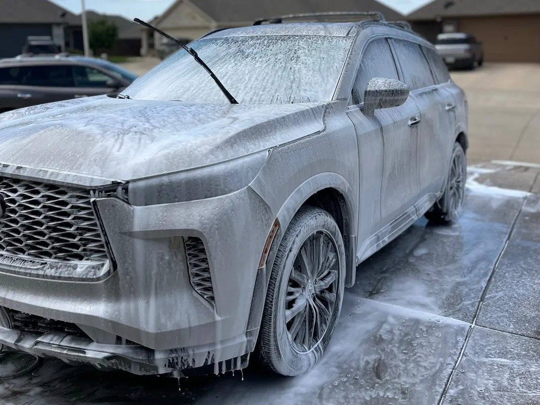 Infiniti QX80 SUV covered in foam during a mobile hand wash